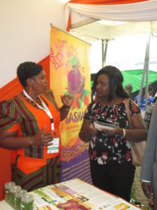 Rosemary Gatimu of CIP-Muguga with a visitior to the CIP stand at the conference