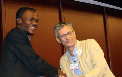 Dr. Graham Thiele, one of the judges, awards Damian Laryea for his winning poster (C. Bukania)