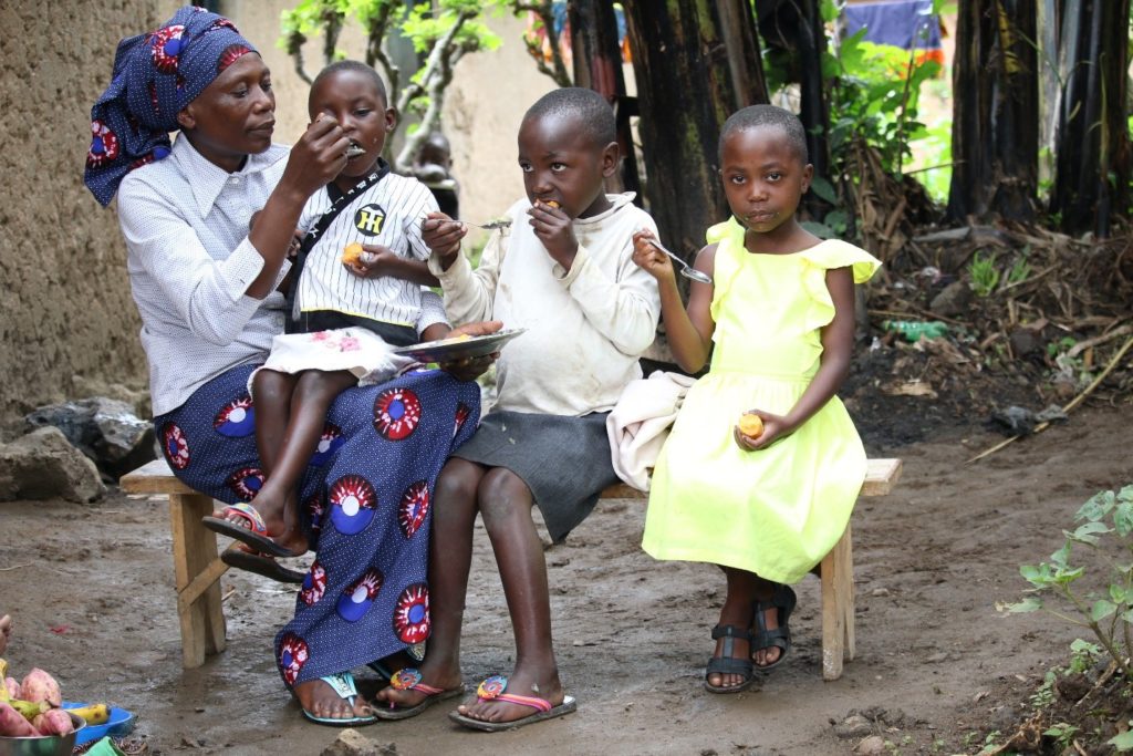Epiphanie at home, feeding her three daughters with food supplemented with OFSP. Photo: Aime Ndayisenga (CIP)