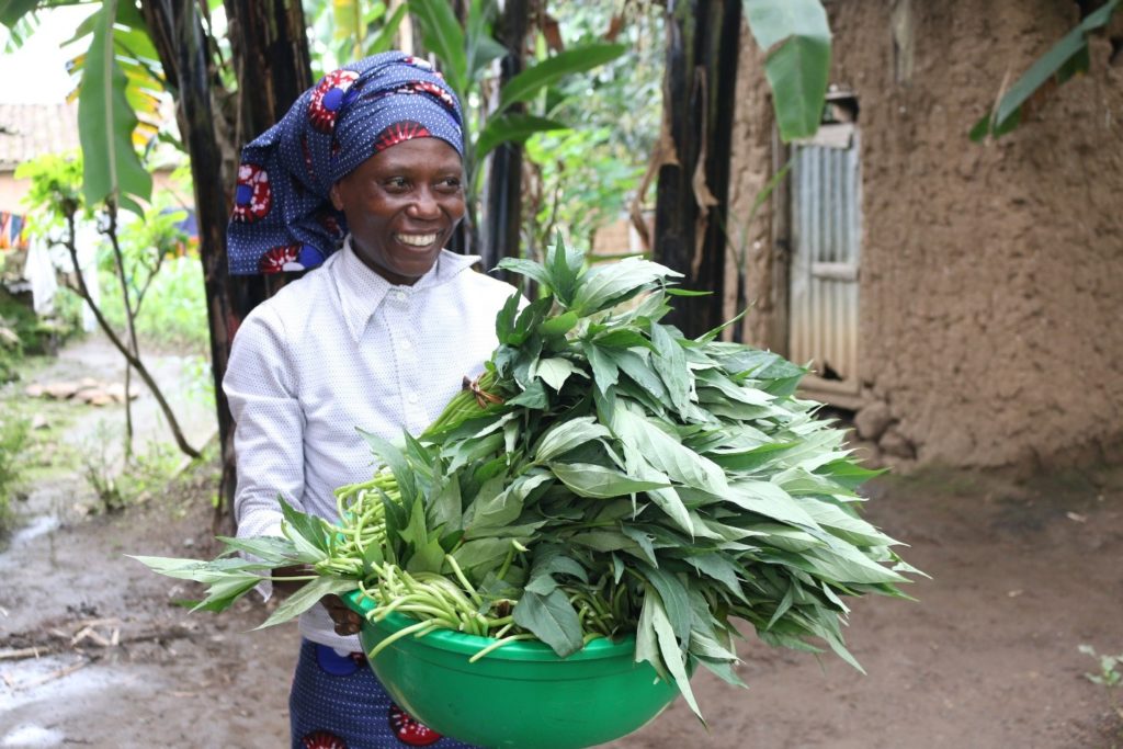 Ahezanaho showing off sweetpotato green leaves she cooks as vegetables and exports in Bukavu/DRC. Photo: Aime Ndayisenga (CIP)